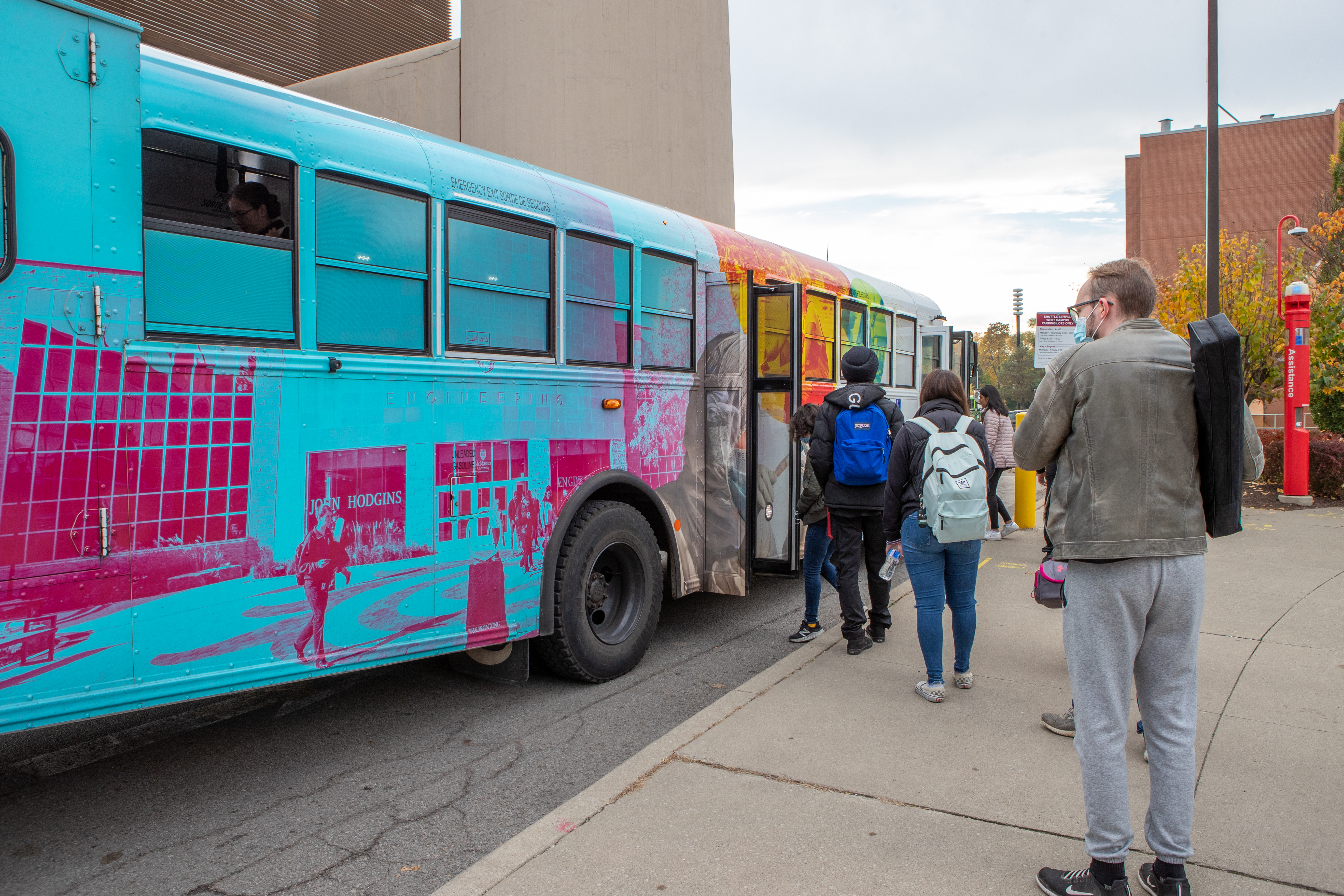 People boarding the McMaster shuttle bus for on-site